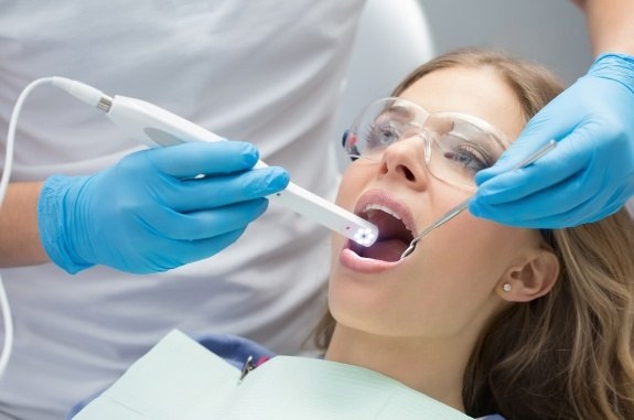Woman receiving dental scan with intraoral camera in Clute