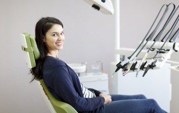Woman smiling in dental chair before receiving dental services in Clute
