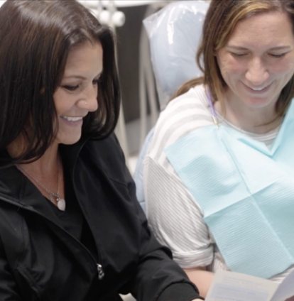 Clute dental team member showing a paper to a patient