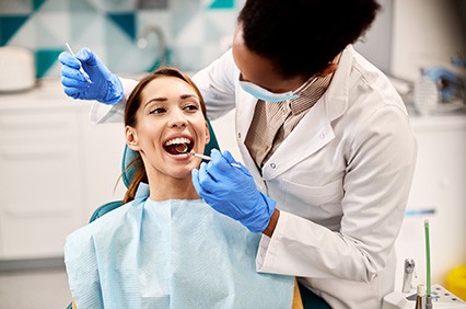 Dentist examining smiling patient's teeth