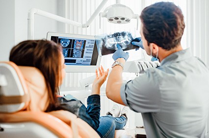 Dentist reviewing X-ray with patient