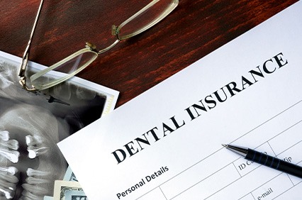 Dental insurance, glasses, and X-ray on desk