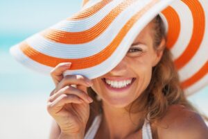 Woman with sunhat smiling on the beach